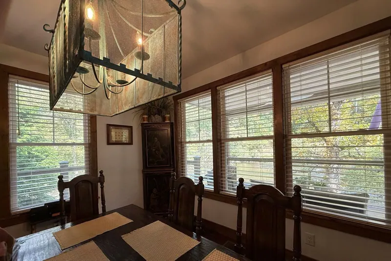 Wood blinds across a wall of dining room windows